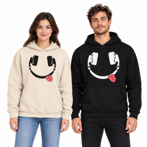 Female and male models wearing cream beige and black headphone smiley face hoodies with pink-red tongue details against a white studio background.
